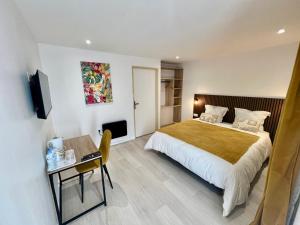 a hotel room with a bed and a desk and a television at L'enclos du volcan in La Plaine des Cafres