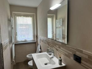 a bathroom with a sink and a toilet and a mirror at CentroCourma e Parcheggio e TopView in Courmayeur
