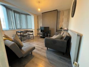 a living room with two couches and a table at 3 bedroom cosy home in Birmingham in Oldbury