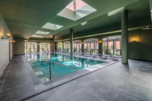 a large swimming pool with chairs in a building at Enotel Santo da Serra in Santo da Serra