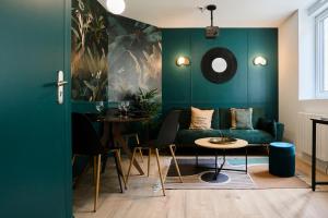 a green living room with a couch and a table at Stardust Croix in Croix