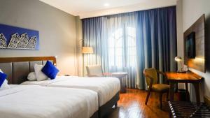 Postel nebo postele na pokoji v ubytování Monopoli Hotel Bukittinggi