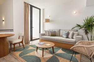 a living room with a couch and a table at Memmo Baleeira - Design Hotels in Sagres +111 photos