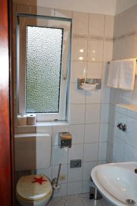 a bathroom with a window and a toilet and a sink at Steens Hotel in Hamburg