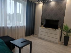 a living room with a television and a white dresser at Apartament LUX w centrum Konina in Konin