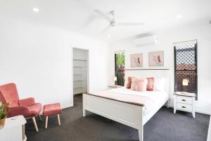 a white bedroom with a bed and a chair at Villa Cattana in Smithfield +14 photos