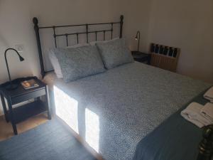 a bedroom with a large bed with a blue comforter at Maison Souquet in Lamalou-les-Bains +13 photos