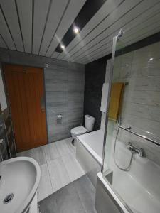a bathroom with a tub and a toilet and a sink at Cozy Blackpool Retreat with 3 Bedrooms in Blackpool +32 photos