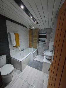 a bathroom with a toilet and a tub and a sink at Cozy Blackpool Retreat with 3 Bedrooms in Blackpool