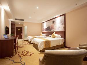 a hotel room with two beds and a desk and chairs at Vienna Hotel Hangzhou Banshan Shiqiao Road in Hangzhou