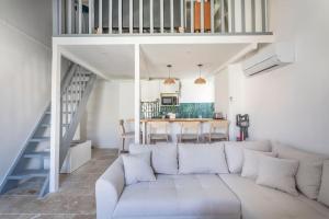a living room with a white couch and a staircase at Standing - Central - Quartier des Artistes - Les Frères de la Loc' in Marseille