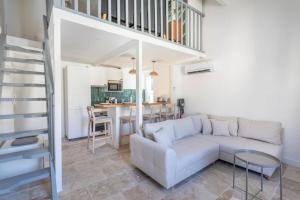 a living room with a white couch and a staircase at Standing - Central - Quartier des Artistes - Les Frères de la Loc' in Marseille +19 photos