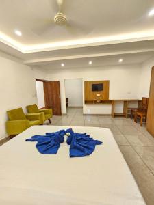 a room with a bed with blue robes on it at Rolax Tourist home in Thekkady