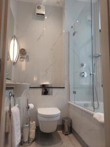a bathroom with a toilet and a glass shower at Gem Fitzrovia Hotel in London