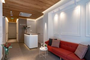 ein Wohnzimmer mit einem roten Sofa und eine Küche in der Unterkunft Sentro Boutique Hotel in Sofia