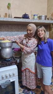 two women standing in a kitchen preparing food at Dar Toda - Zagora guest house in Zagora