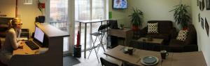 a woman sitting at a desk with a computer in a room at Hostel Tivoli in Ljubljana