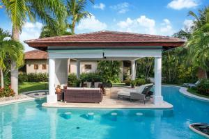 a gazebo next to a swimming pool at Beautiful Villa with Pool, Gym & Maid in Punta Cana