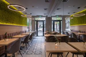 ein Restaurant mit Tischen und Stühlen und grünen Wänden in der Unterkunft Sentro Boutique Hotel in Sofia