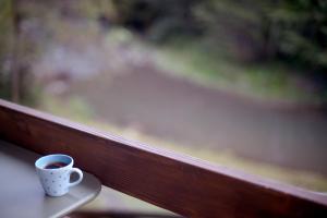 a cup of coffee sitting on a window sill at Apartmani Rimski most in Ivanjica