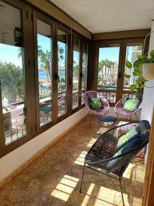 a balcony with chairs and windows with a view of the beach at Sunbeach Malagueta in Málaga