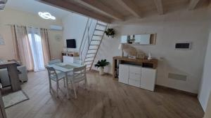 a living room with a table and a staircase at La casa delle rose 3 in Giba