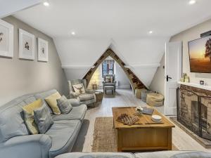 a living room with a couch and a table at One Grooms Cottage, Dunster in Dunster