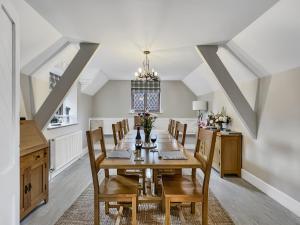 a dining room with a wooden table and chairs at One Grooms Cottage, Dunster in Dunster