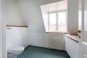 Un baño con inodoro, lavabo y ventana. en 2BR with Amazing City Skyline View, en Copenhague 46 fotos más