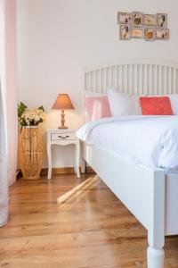Un dormitorio con una cama blanca y una mesa con lámpara. en City Center - Studio T by MRG Apartments, en Bucarest