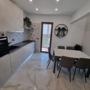 a kitchen with a table and chairs in a room at Appartamento Sanzio, centro Monfalcone in Monfalcone