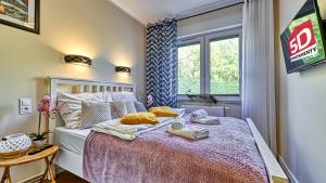 a bedroom with a bed with towels on it at Apartament Podróżniczy z prywatną Sauną blisko Elementsa - 5D Apartments in Świeradów-Zdrój
