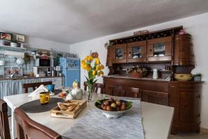 a kitchen with a table with a bowl of fruit on it at Sa Dommo de Luigi in Orosei +18 photos