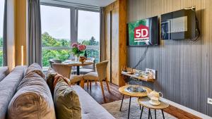 salon z kanapą i telewizorem w obiekcie Apartament SPA 56 Resort Kozubnik blisko Szczyrk - 5D Apartamenty w mieście Porąbka