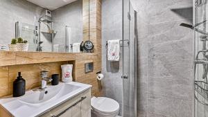 łazienka z prysznicem, umywalką i toaletą w obiekcie Apartament SPA 56 Resort Kozubnik blisko Szczyrk - 5D Apartamenty w mieście Porąbka +37 zdjęć