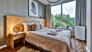 sypialnia z łóżkiem i dużym oknem w obiekcie Apartament SPA 56 Resort Kozubnik blisko Szczyrk - 5D Apartamenty w mieście Porąbka