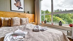 sypialnia z ręcznikami na łóżku z oknem w obiekcie Apartament SPA 56 Resort Kozubnik blisko Szczyrk - 5D Apartamenty w mieście Porąbka