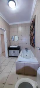 a bathroom with a tub and a sink and a toilet at St Michael & The Queen in Johannesburg +291 photos