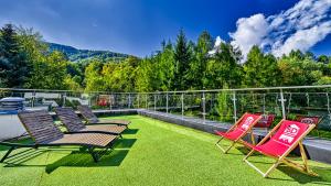 grupa krzeseł siedzących na patio z trawą w obiekcie Apartament SPA 56 Resort Kozubnik blisko Szczyrk - 5D Apartamenty w mieście Porąbka