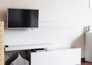 a flat screen tv hanging on a white wall at Bologna's Heart at Farini 31 in Bologna