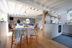 une cuisine et une salle à manger avec une table et des chaises dans l'établissement Dipple Mill Cottage, à Bideford