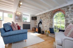 un salon avec un mur en pierre dans l'établissement Dipple Mill Cottage, à Bideford