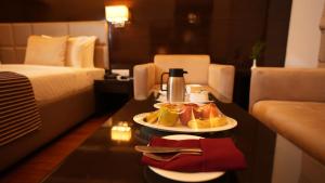 una habitación de hotel con un plato de comida en una mesa en Hotel Africa Avenue - Greater Kailash 1, en Nueva Delhi
