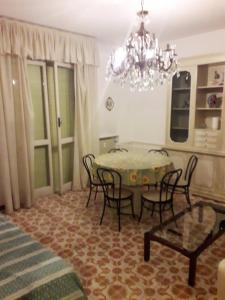 Un comedor con una mesa con sillas y una lámpara de araña. en Trilocale con posto auto privato a 5 minuti a piedi dalla spiaggia, en Rapallo 10 fotos más