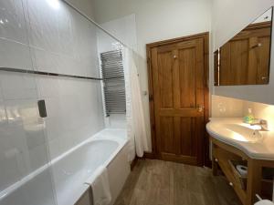a bathroom with a tub and a sink at Deer Close Cottage in Keswick +11 photos