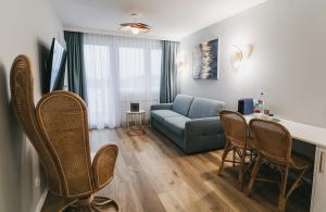 a living room with a couch and a table and chairs at Dukat Medical Spa in Dąbki