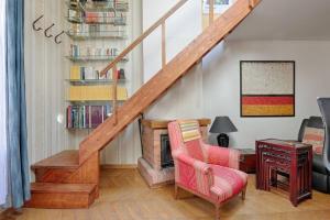 a living room with a staircase and a chair at Les bamboos de Malakoff Paris in Malakoff