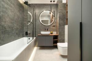 a bathroom with a sink and a mirror at Kilińskiego Prestigious Apartment with Parking by Renters Prestige in Łódź