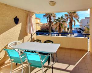 d'une table et de chaises sur un balcon avec des palmiers. dans l'établissement T2 Écume Vue Mer Terrasse Parking, à Palavas-les-Flots