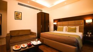 una habitación de hotel con una cama y un sofá en Hotel Africa Avenue - Greater Kailash 1, en Nueva Delhi 14 fotos más